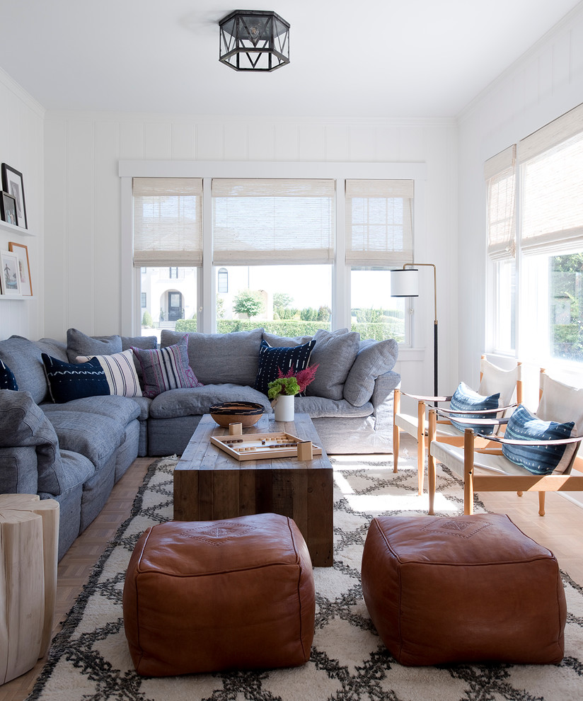 Inspiration for a coastal medium tone wood floor family room remodel in New York with white walls