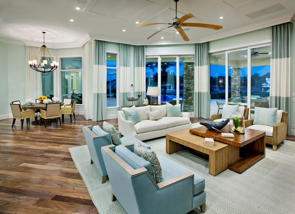 Стильный дизайн: большая открытая гостиная комната в морском стиле с синими стенами и паркетным полом среднего тона без телевизора - последний тренд