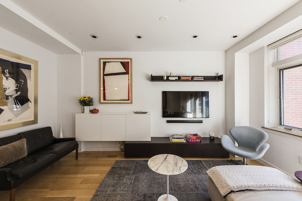 Пример оригинального дизайна: маленькая изолированная гостиная комната в стиле модернизм с белыми стенами, светлым паркетным полом, телевизором на стене и бежевым полом для на участке и в саду