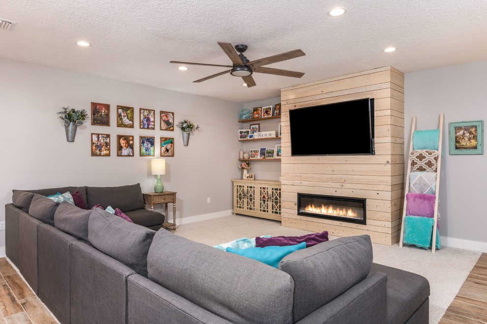 Modelo de sala de estar machihembrado y abierta de estilo americano de tamaño medio con paredes grises, moqueta, chimenea lineal, pared multimedia y suelo beige