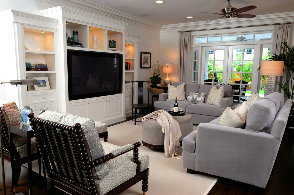 Immagine di un soggiorno stile americano di medie dimensioni con pareti bianche, parquet scuro, nessun camino, parete attrezzata e pavimento marrone