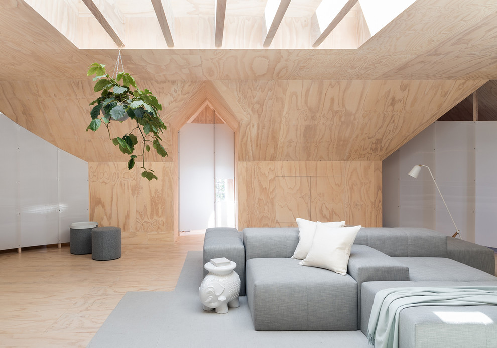 Offenes Nordisches Wohnzimmer ohne Kamin mit Sperrholzboden und beiger Wandfarbe in Seattle