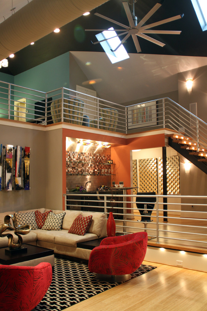 Ispirazione per un ampio soggiorno design stile loft con pareti arancioni, pavimento in bambù e TV a parete