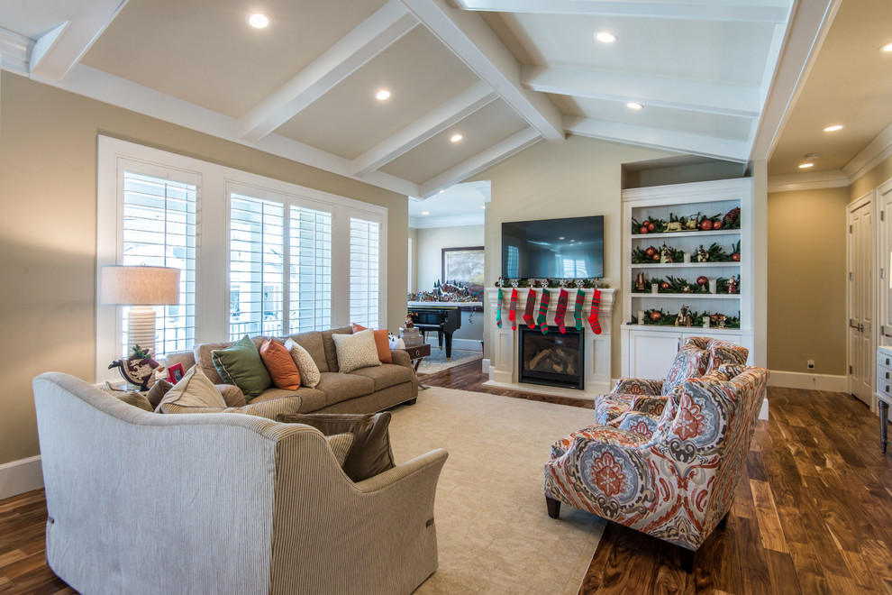 Design ideas for a medium sized classic open plan games room in Salt Lake City with beige walls, medium hardwood flooring, a standard fireplace, a wooden fireplace surround and a wall mounted tv.