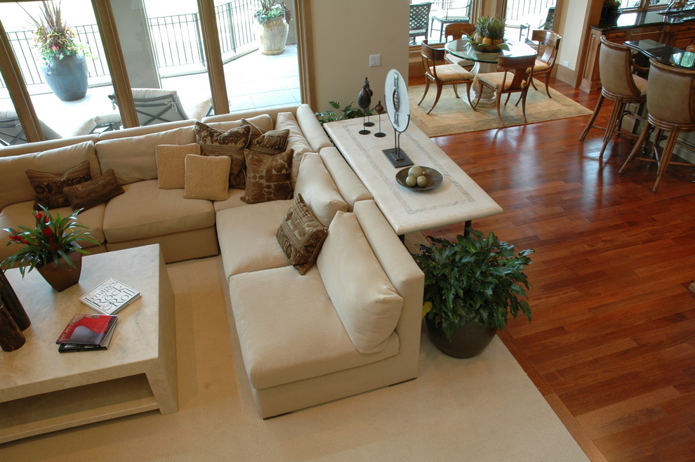 Aménagement d'une grande salle de séjour classique ouverte avec salle de jeu, un mur beige, un sol en bois brun et un téléviseur encastré.