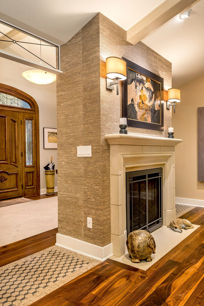Diseño de sala de estar abierta contemporánea de tamaño medio con paredes grises, suelo de madera en tonos medios, todas las chimeneas, marco de chimenea de piedra y televisor colgado en la pared