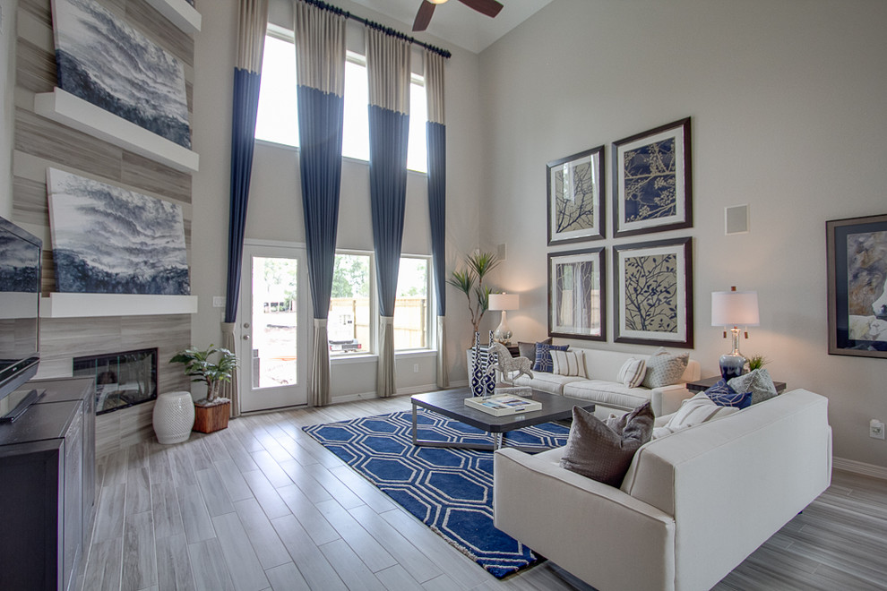 Offenes Modernes Wohnzimmer mit Eckkamin, gefliester Kaminumrandung, freistehendem TV und grauer Wandfarbe in Houston