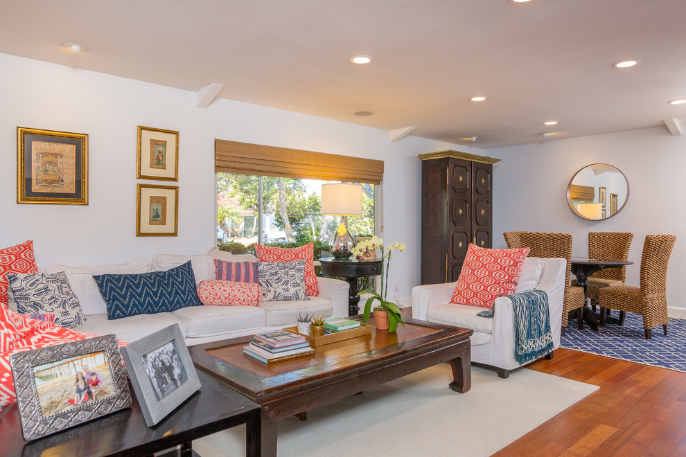 Example of a mid-sized eclectic open concept dark wood floor family room design in Orange County with a standard fireplace, a brick fireplace, a wall-mounted tv and white walls