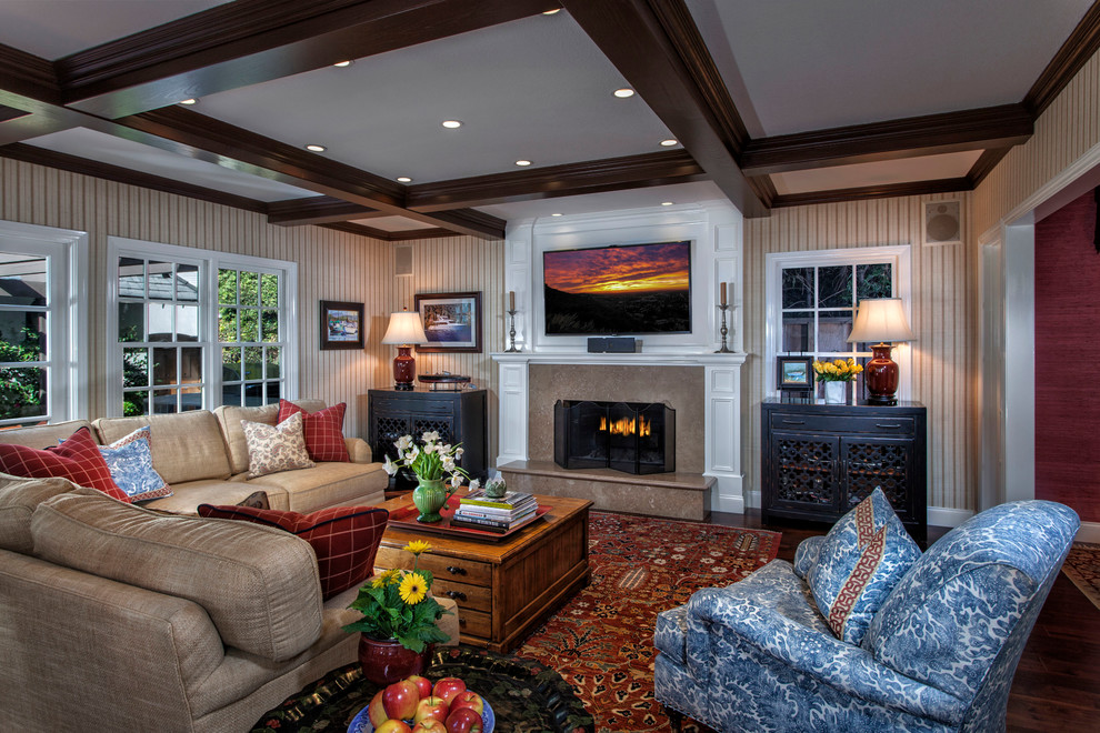 Design ideas for a medium sized classic open plan games room in Orange County with dark hardwood flooring, a standard fireplace, a wooden fireplace surround, beige walls and a wall mounted tv.