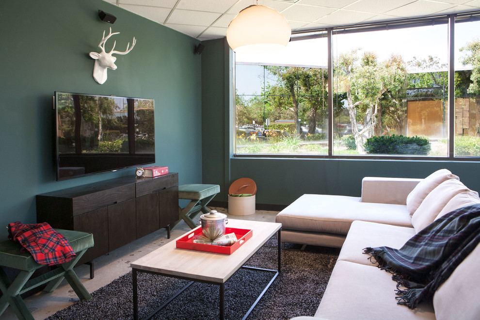 Réalisation d'une salle de séjour design avec un mur vert et un téléviseur fixé au mur.