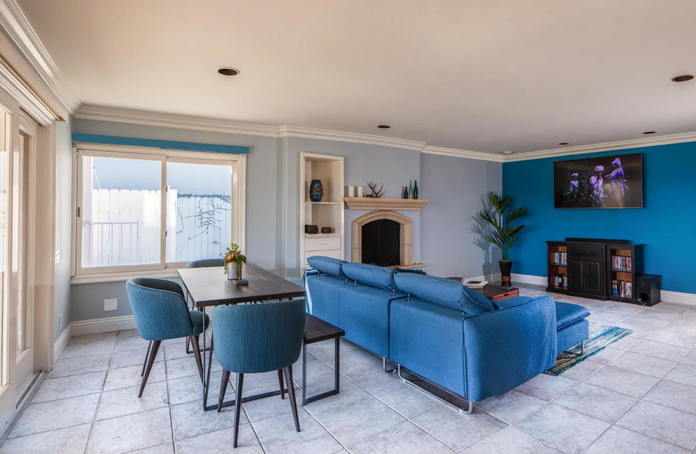 На фото: изолированная гостиная комната среднего размера в морском стиле с домашним баром, синими стенами, полом из керамогранита, стандартным камином, фасадом камина из камня, телевизором на стене и серым полом