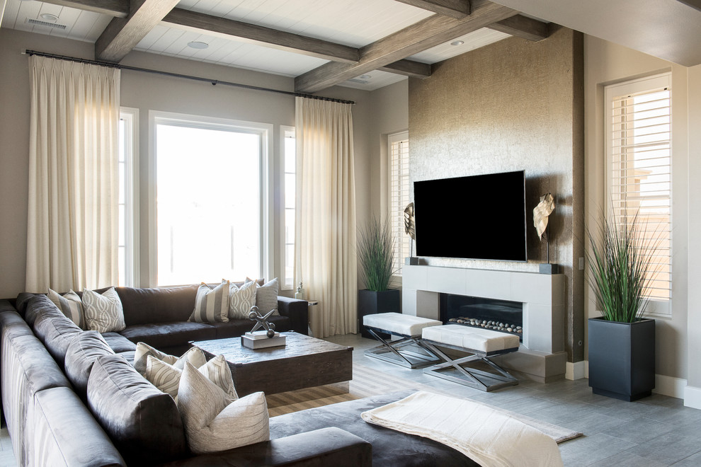 Ejemplo de sala de estar abierta contemporánea de tamaño medio con paredes beige, suelo de madera clara, chimenea lineal, televisor colgado en la pared, suelo gris y marco de chimenea de piedra