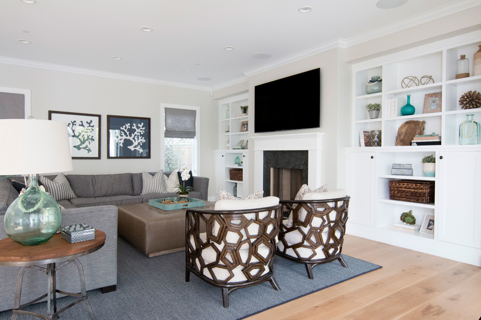 Imagen de sala de estar abierta de estilo de casa de campo grande con paredes blancas, suelo de madera clara, todas las chimeneas, marco de chimenea de piedra y televisor colgado en la pared