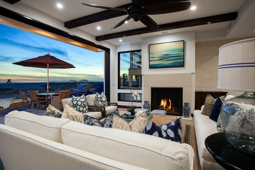 Imagen de sala de estar costera con suelo de madera en tonos medios