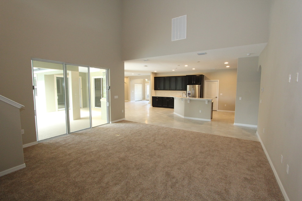 Modelo de sala de estar abierta tradicional renovada grande con paredes beige, moqueta y suelo beige