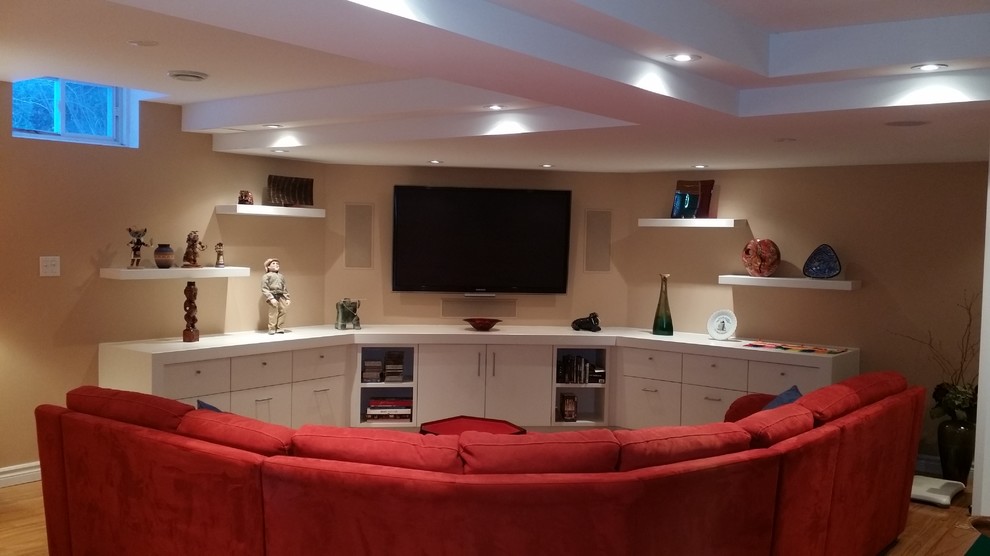Modelo de sala de juegos en casa abierta actual grande con paredes beige y televisor en una esquina
