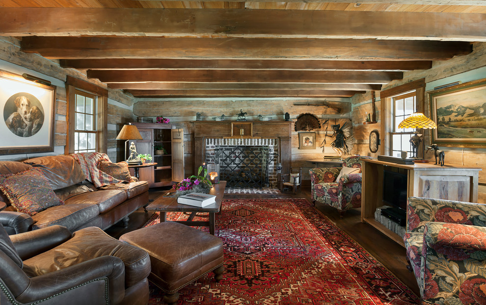This is an example of a large rustic enclosed games room in Charleston with brown walls, medium hardwood flooring, a standard fireplace, a brick fireplace surround and a built-in media unit.