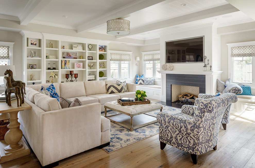 Klassisches Wohnzimmer mit TV-Wand, beiger Wandfarbe, hellem Holzboden, Kamin und beigem Boden in San Diego