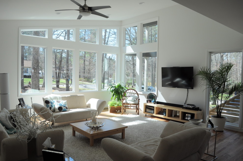 Mittelgroßes, Offenes Skandinavisches Wohnzimmer ohne Kamin mit weißer Wandfarbe, hellem Holzboden und TV-Wand in Raleigh
