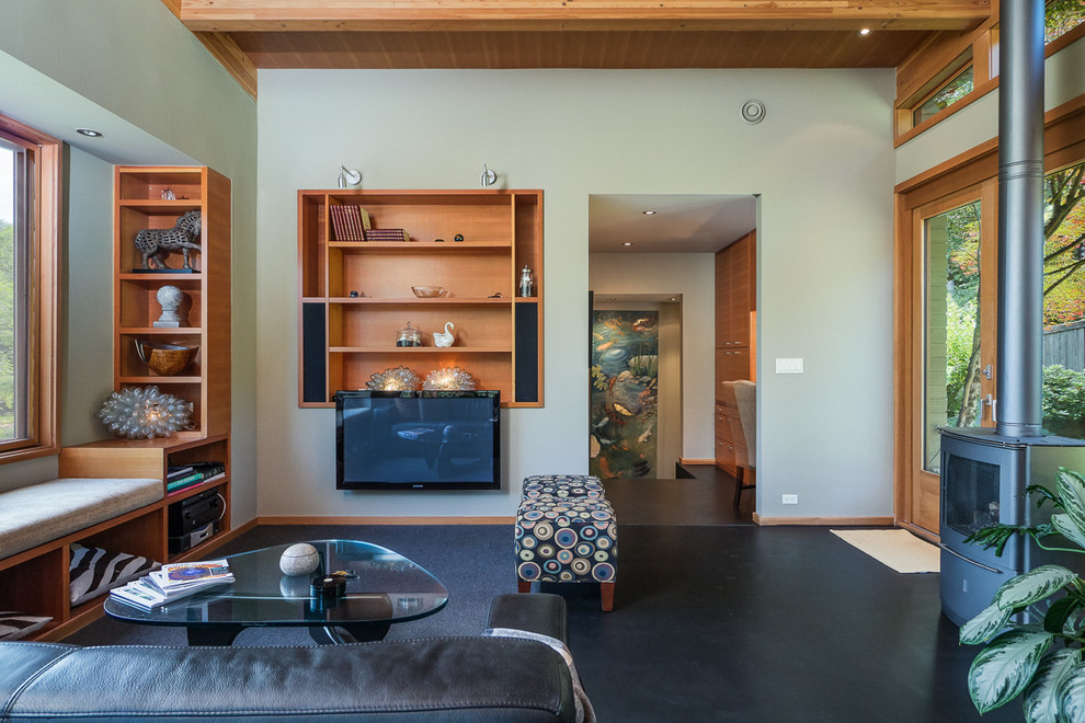 Inspiration pour une salle de séjour minimaliste de taille moyenne et ouverte avec un mur vert, sol en béton ciré, un manteau de cheminée en métal et un téléviseur fixé au mur.