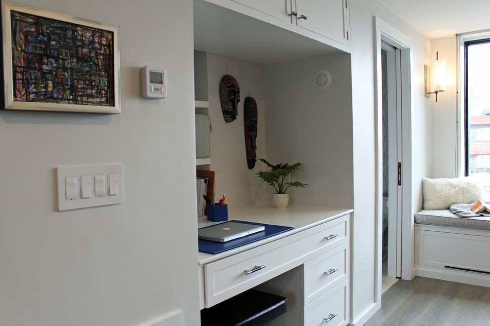 Imagen de sala de estar abierta clásica renovada pequeña sin chimenea con paredes grises, suelo de madera en tonos medios, televisor colgado en la pared y suelo gris