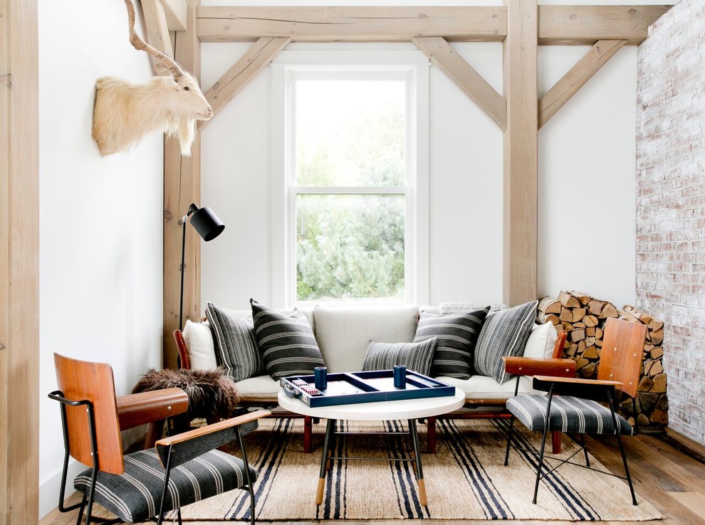 Modelo de sala de estar abierta de estilo de casa de campo con paredes blancas, suelo de madera clara y suelo marrón
