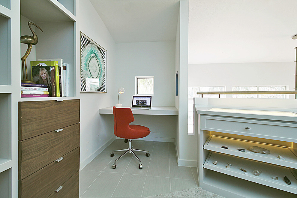 Esempio di un piccolo soggiorno eclettico con pareti bianche, libreria, moquette e pavimento grigio