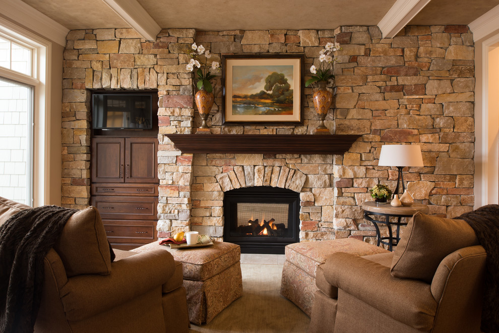 Imagen de salón tradicional con marco de chimenea de piedra, televisor colgado en la pared y todas las chimeneas