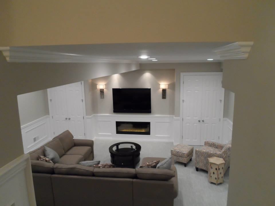 На фото: изолированная гостиная комната среднего размера в классическом стиле с серыми стенами, ковровым покрытием, горизонтальным камином, телевизором на стене, фасадом камина из металла и бежевым полом с