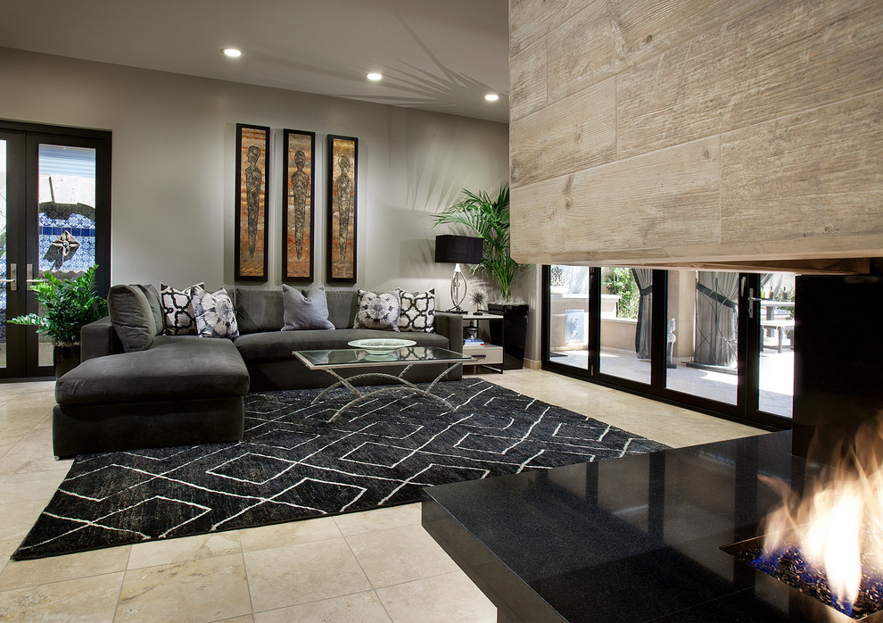 Imagen de sala de estar cerrada actual grande con paredes beige, suelo de mármol, marco de chimenea de madera, televisor colgado en la pared y chimenea de esquina