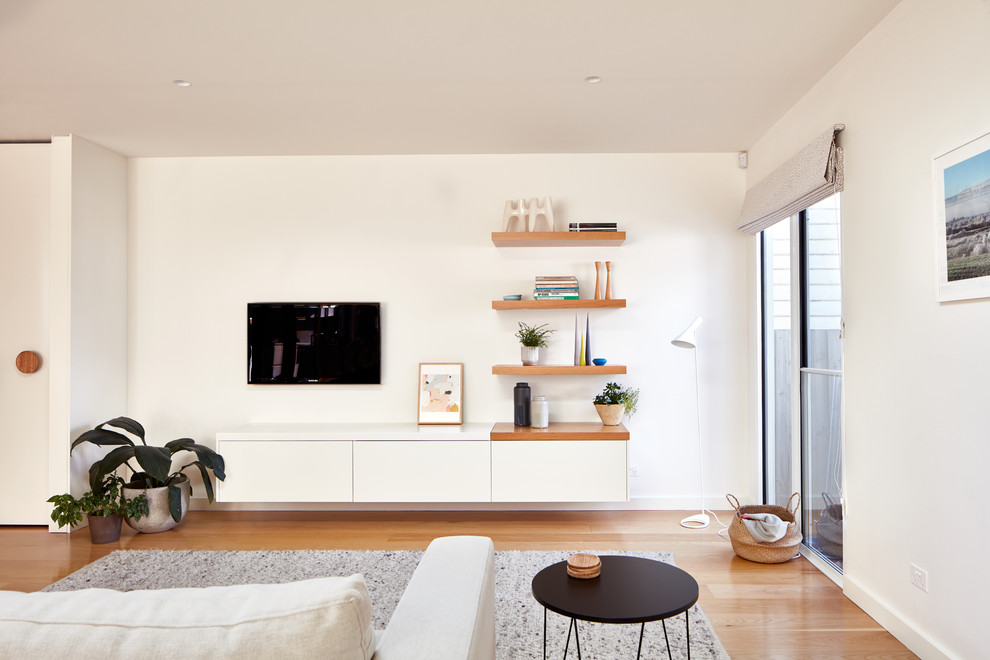 Idee per un soggiorno minimal di medie dimensioni e aperto con pareti bianche, parquet chiaro e TV a parete