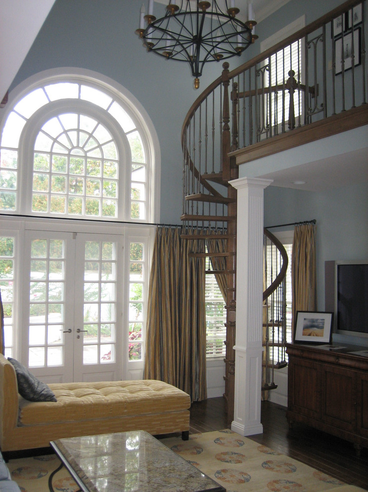 Diseño de sala de estar con biblioteca tipo loft clásica de tamaño medio con paredes azules, suelo de madera en tonos medios y televisor colgado en la pared
