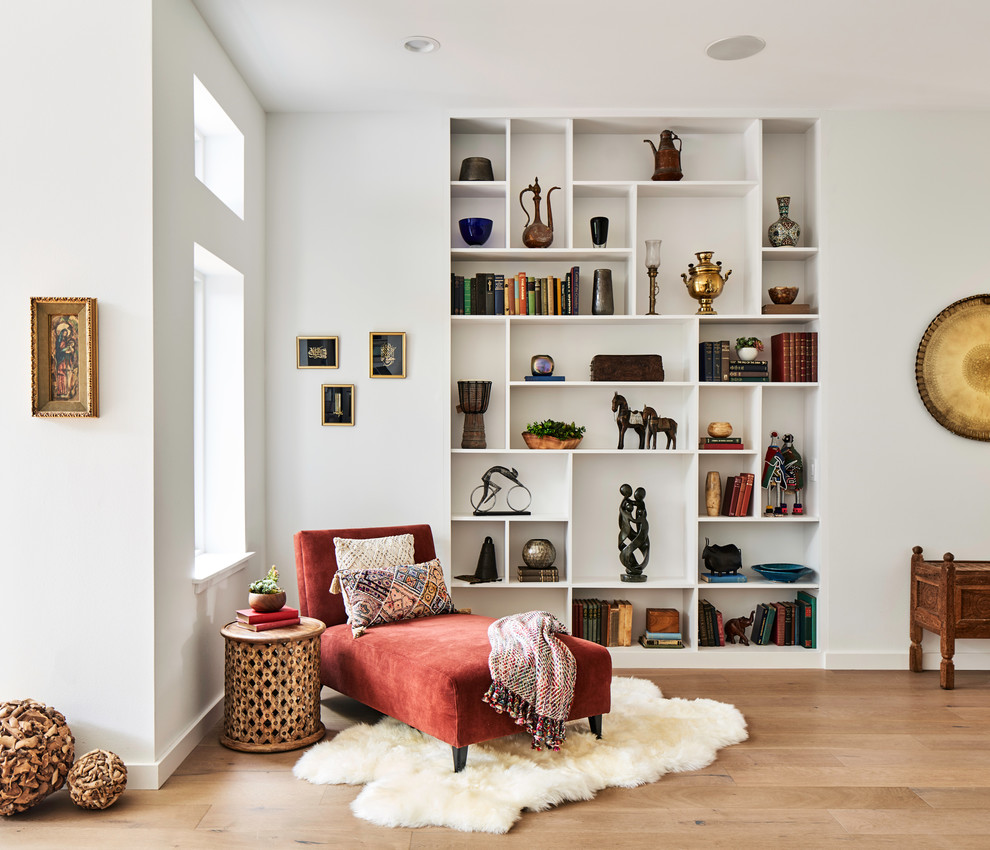 Diseño de sala de estar con biblioteca abierta retro grande con paredes blancas, suelo de madera clara, suelo beige y alfombra