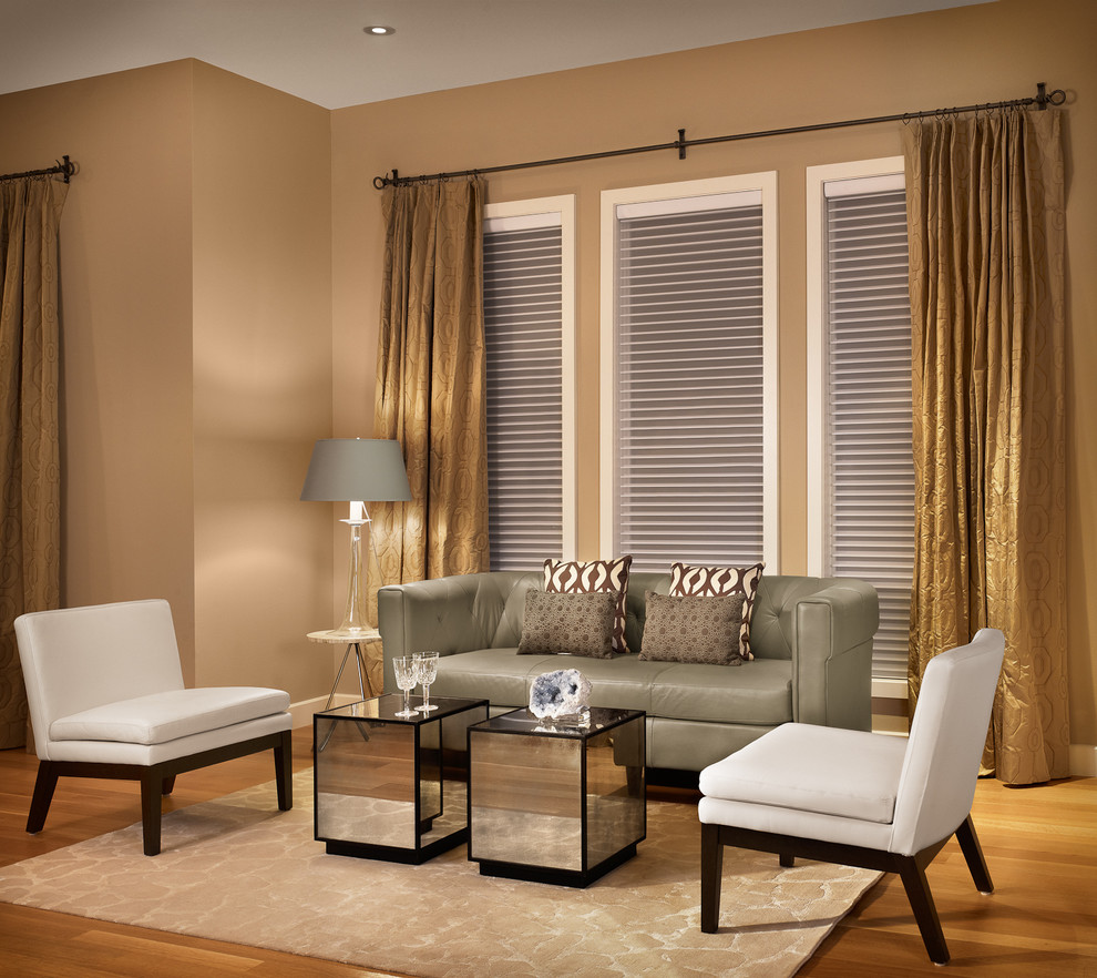 Modelo de sala de estar actual de tamaño medio con paredes beige y suelo de madera en tonos medios