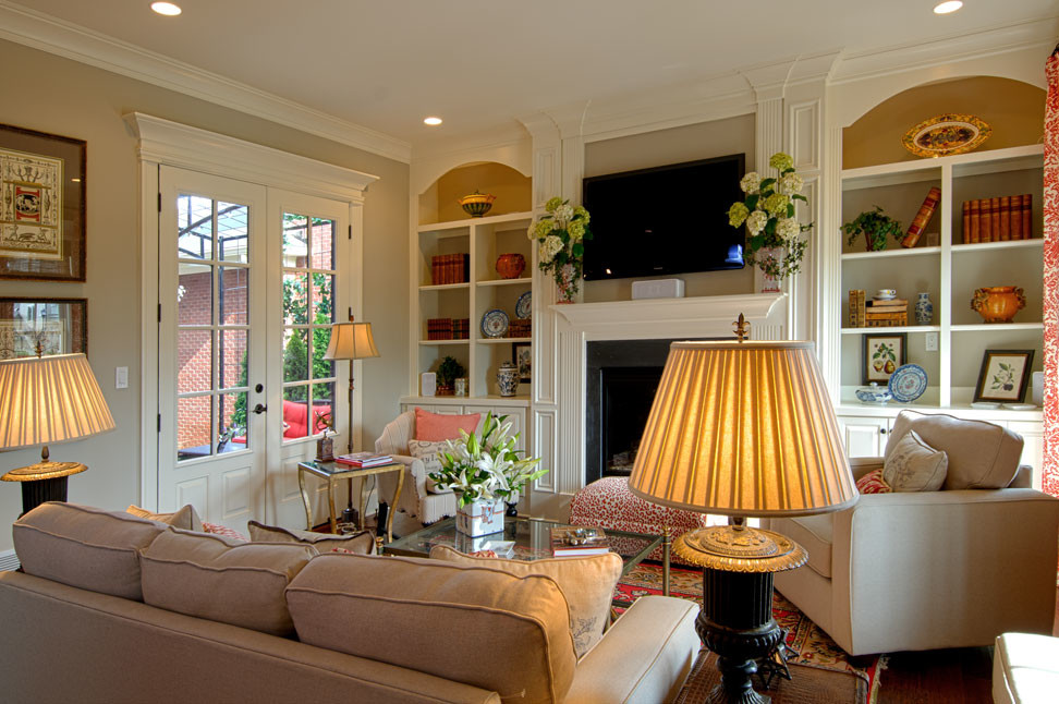 Foto de sala de estar clásica de tamaño medio con suelo de madera en tonos medios, todas las chimeneas, marco de chimenea de madera y televisor colgado en la pared