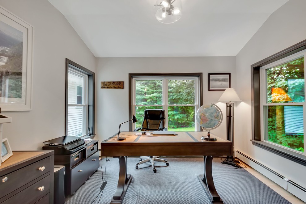 Photo of a classic home office in Boston with light hardwood flooring.
