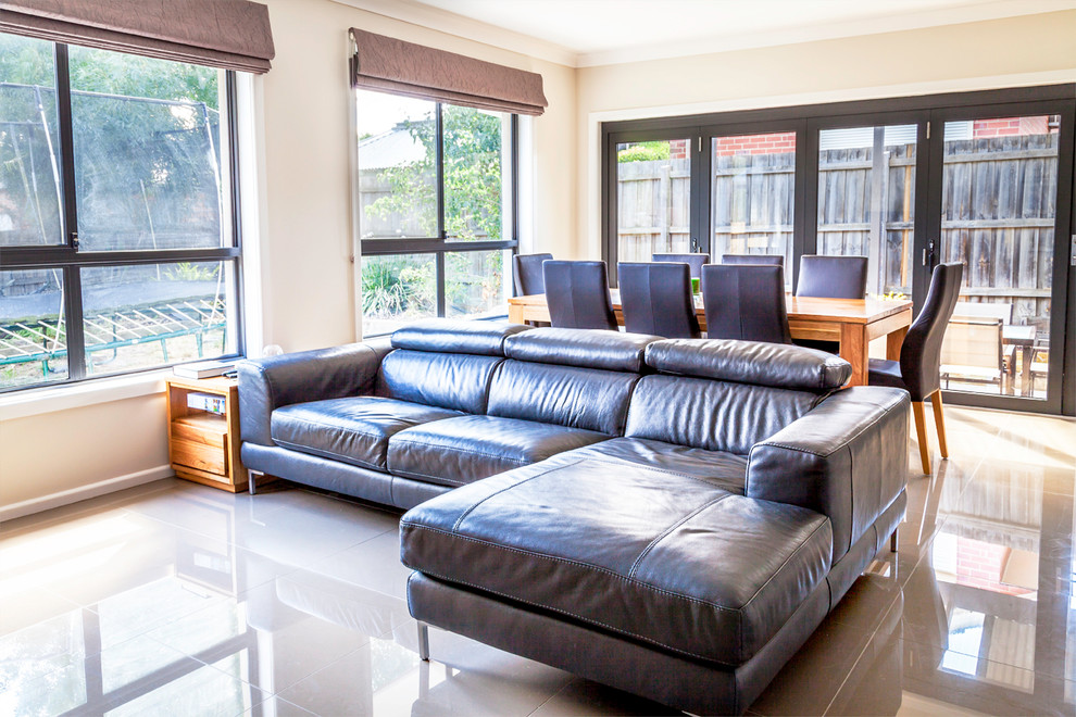 Foto di un soggiorno contemporaneo aperto con pavimento con piastrelle in ceramica, TV autoportante e pareti beige