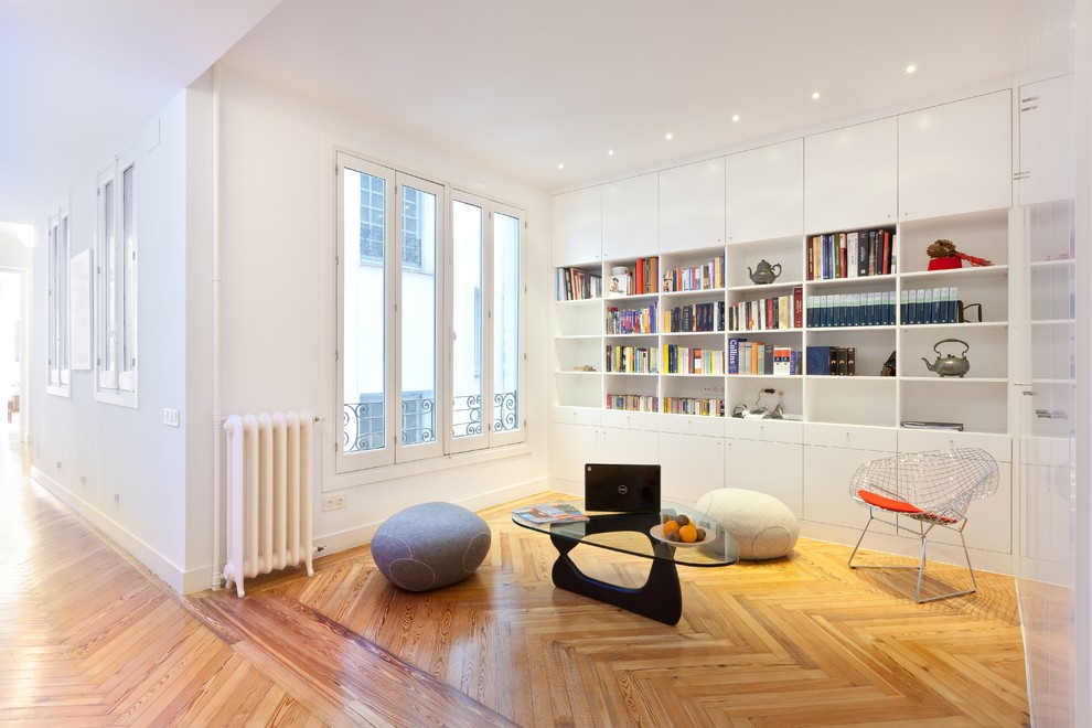 Foto di un piccolo soggiorno design aperto con libreria, pareti bianche, pavimento in legno massello medio, nessun camino e nessuna TV