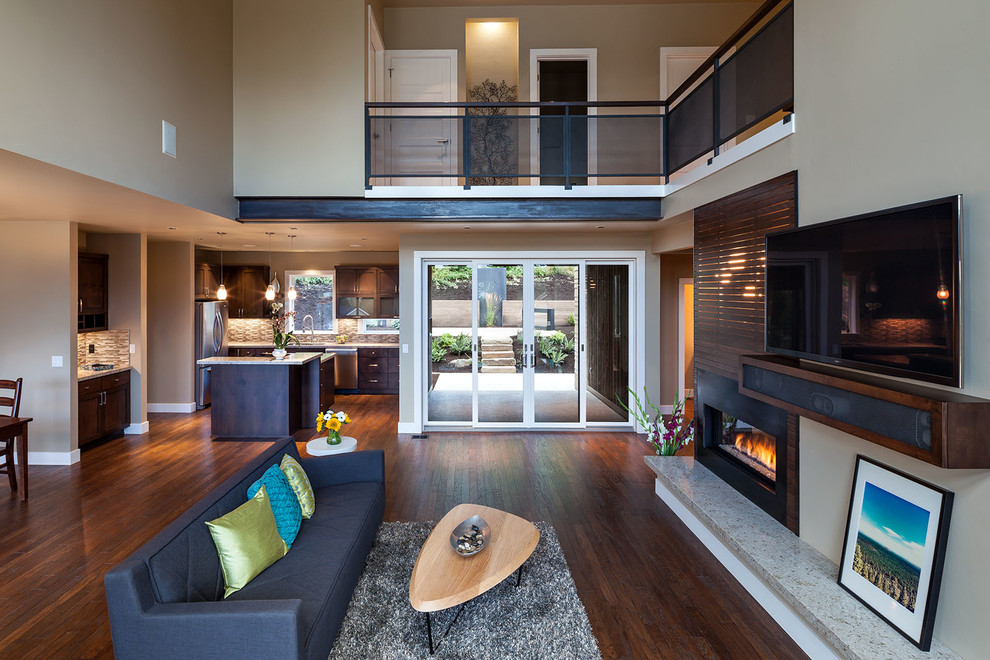Offenes, Großes Modernes Wohnzimmer mit beiger Wandfarbe, braunem Holzboden, Tunnelkamin, Kaminumrandung aus Holz und TV-Wand in Portland