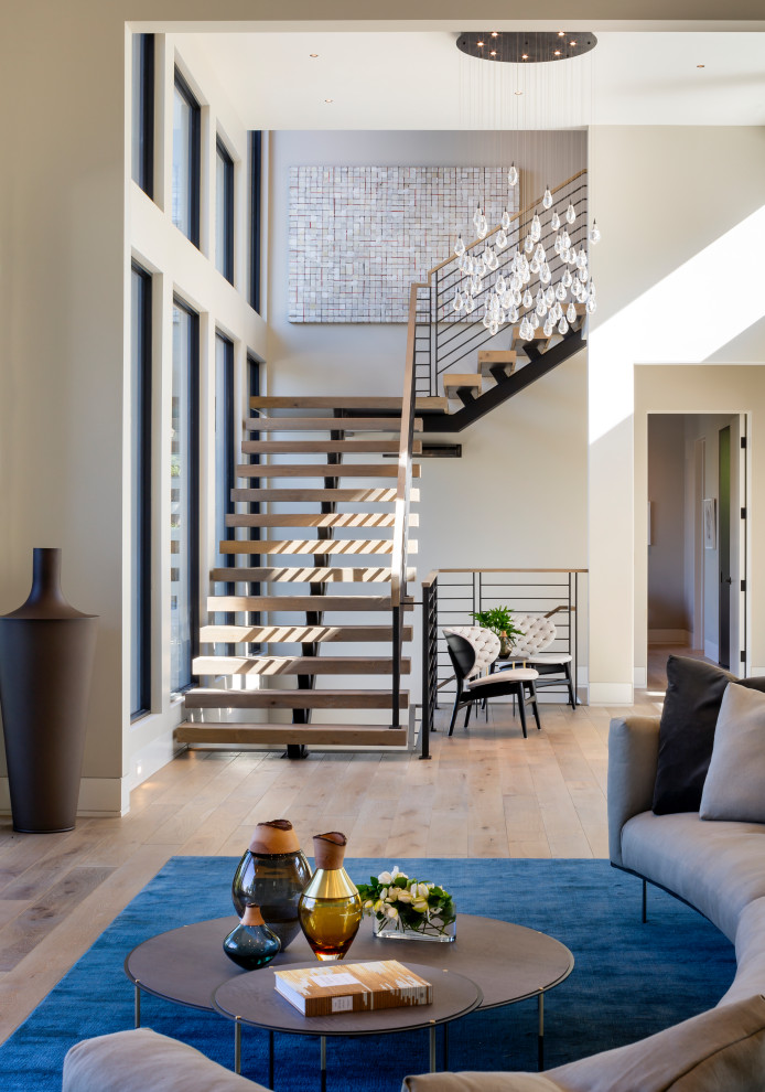 Inspiration pour une grande salle de séjour design ouverte avec un mur beige, parquet clair, une cheminée ribbon et un manteau de cheminée en métal.