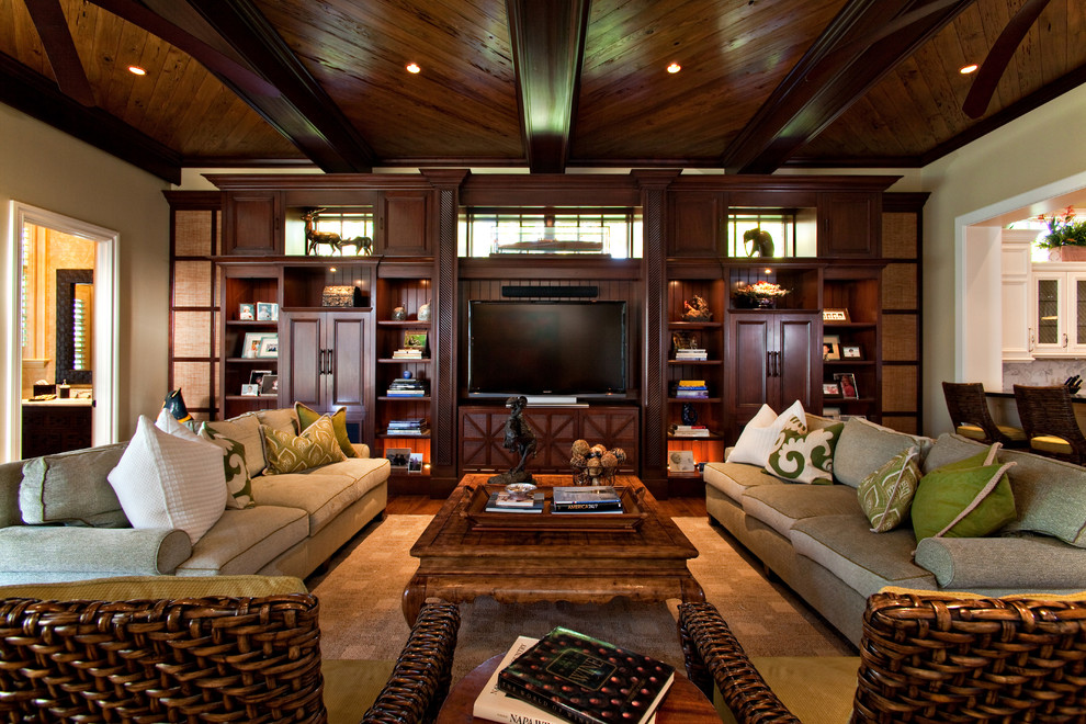 Diseño de sala de estar abierta tradicional grande sin chimenea con paredes beige, suelo de madera en tonos medios y pared multimedia