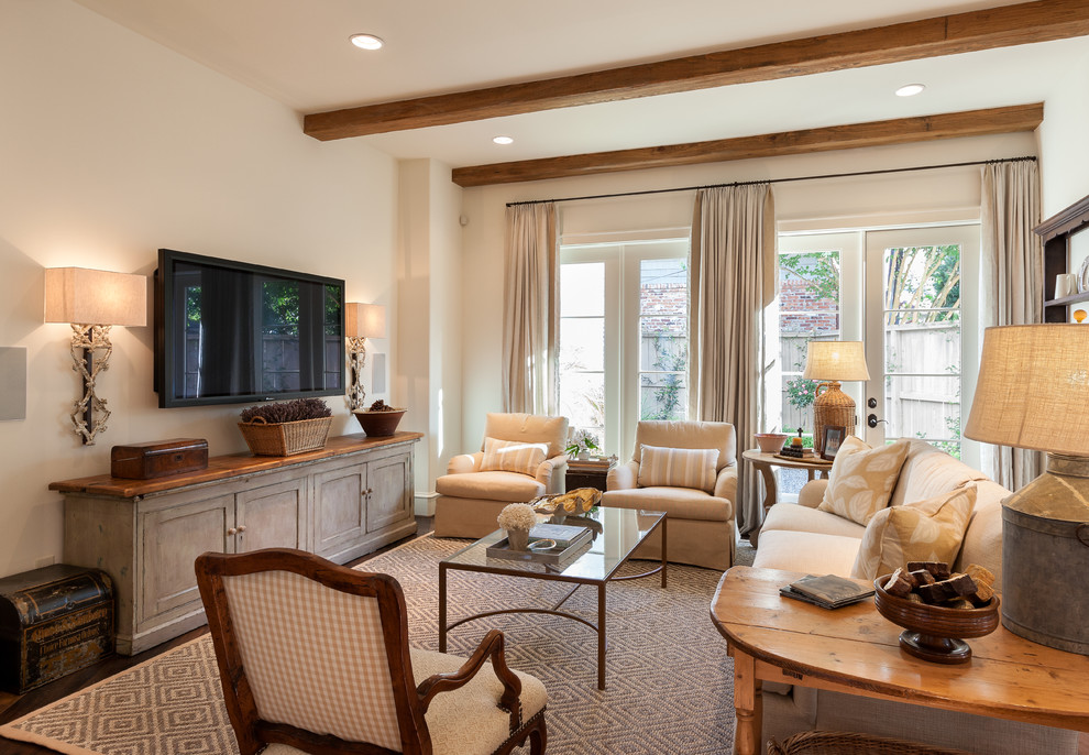 Family room - mid-sized traditional enclosed dark wood floor and brown floor family room idea in Houston with beige walls, a wall-mounted tv and no fireplace