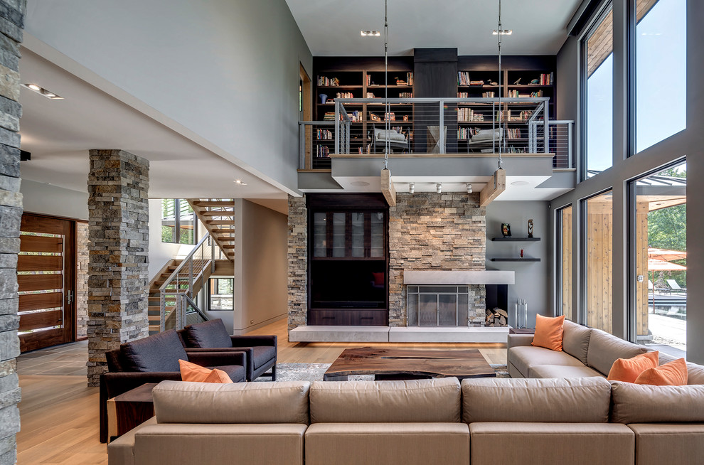 Inspiration for a contemporary open concept light wood floor living room remodel in Detroit with gray walls, a standard fireplace and a stone fireplace
