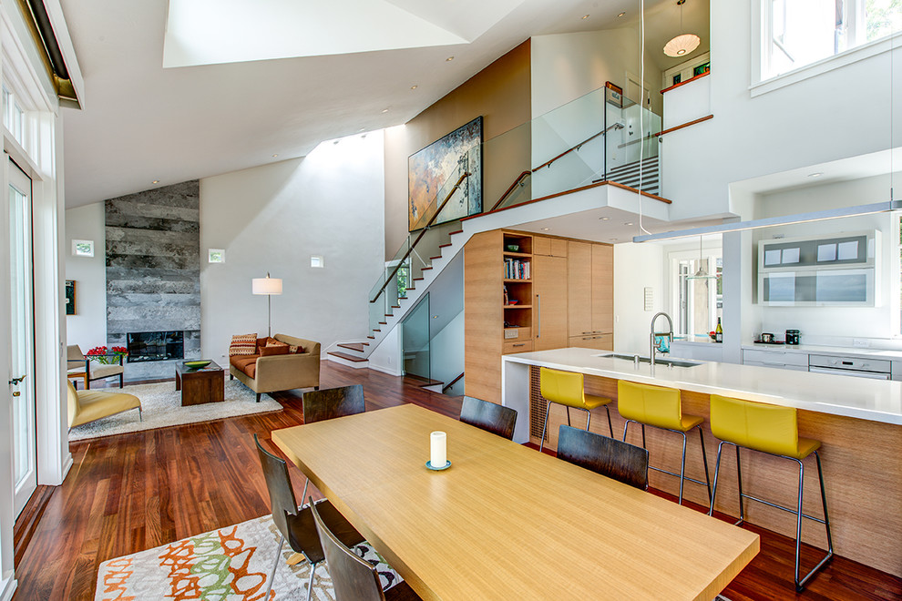 Diseño de sala de estar abierta contemporánea extra grande sin televisor con paredes blancas, marco de chimenea de piedra y suelo de madera en tonos medios