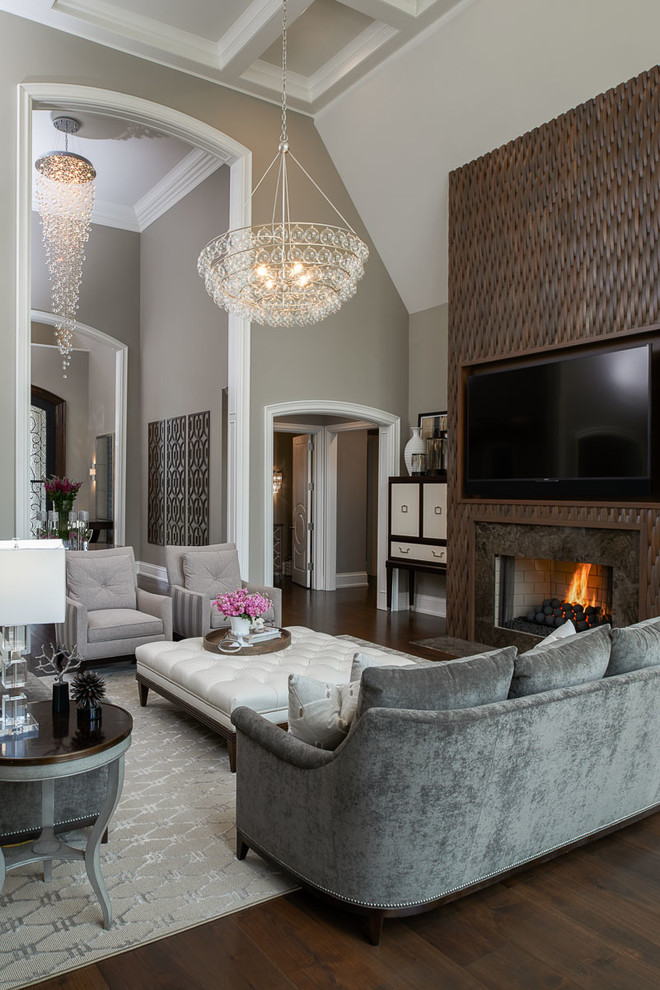 Aménagement d'une très grande salle de séjour contemporaine ouverte avec un mur gris, parquet foncé, une cheminée standard, un manteau de cheminée en bois et un téléviseur encastré.