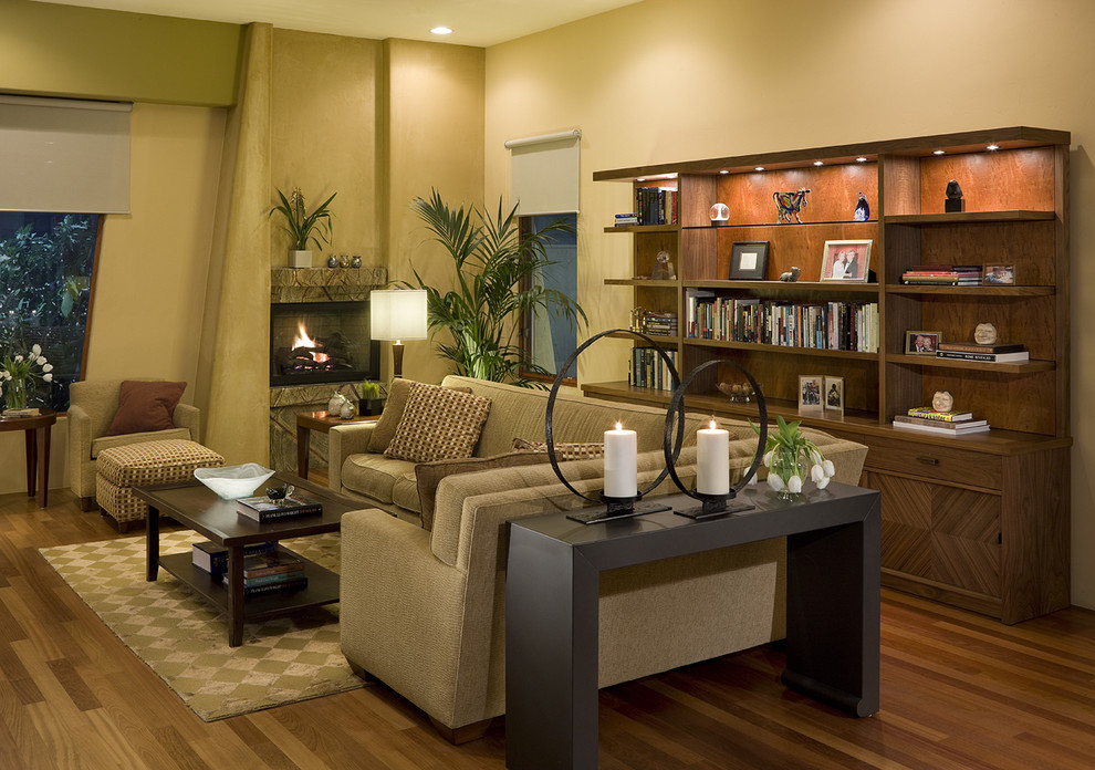 Modelo de sala de estar abierta contemporánea extra grande con suelo de madera en tonos medios, todas las chimeneas, marco de chimenea de piedra, pared multimedia y paredes amarillas