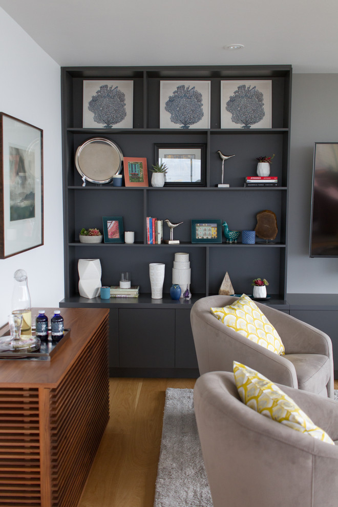 Ejemplo de sala de estar abierta moderna de tamaño medio con paredes blancas, suelo de madera en tonos medios, televisor colgado en la pared y suelo blanco