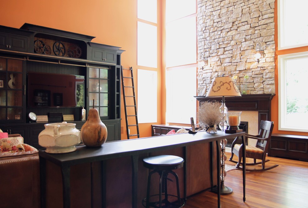 На фото: большая открытая гостиная комната в стиле неоклассика (современная классика) с оранжевыми стенами с