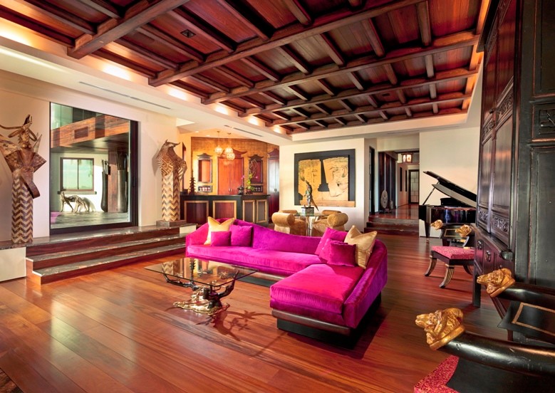 Example of a huge zen enclosed dark wood floor family room design in Miami with a bar, beige walls and a concealed tv