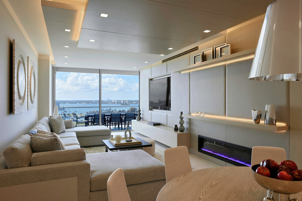 Идея дизайна: открытая гостиная комната в современном стиле с белыми стенами, горизонтальным камином, телевизором на стене и бежевым полом